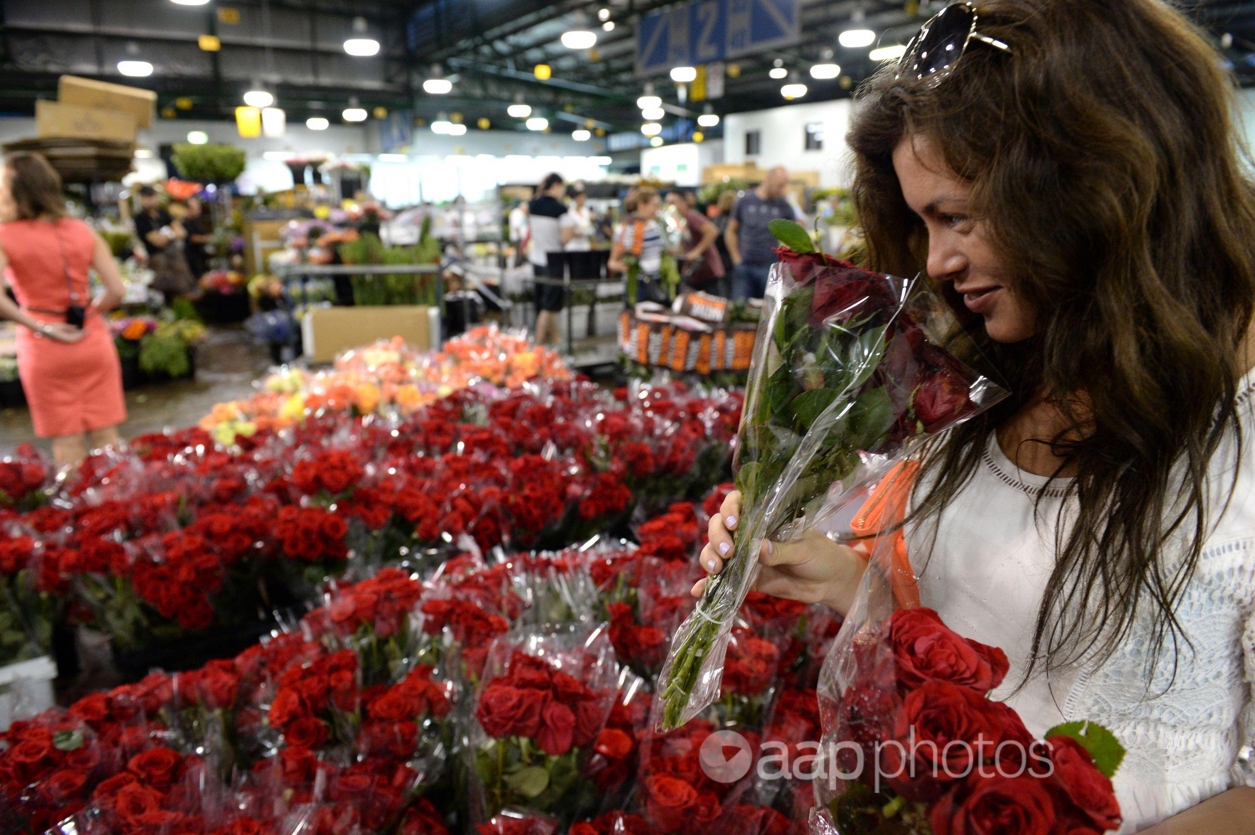 A woman buys roses at the Sydney Flower Market in Sydney.