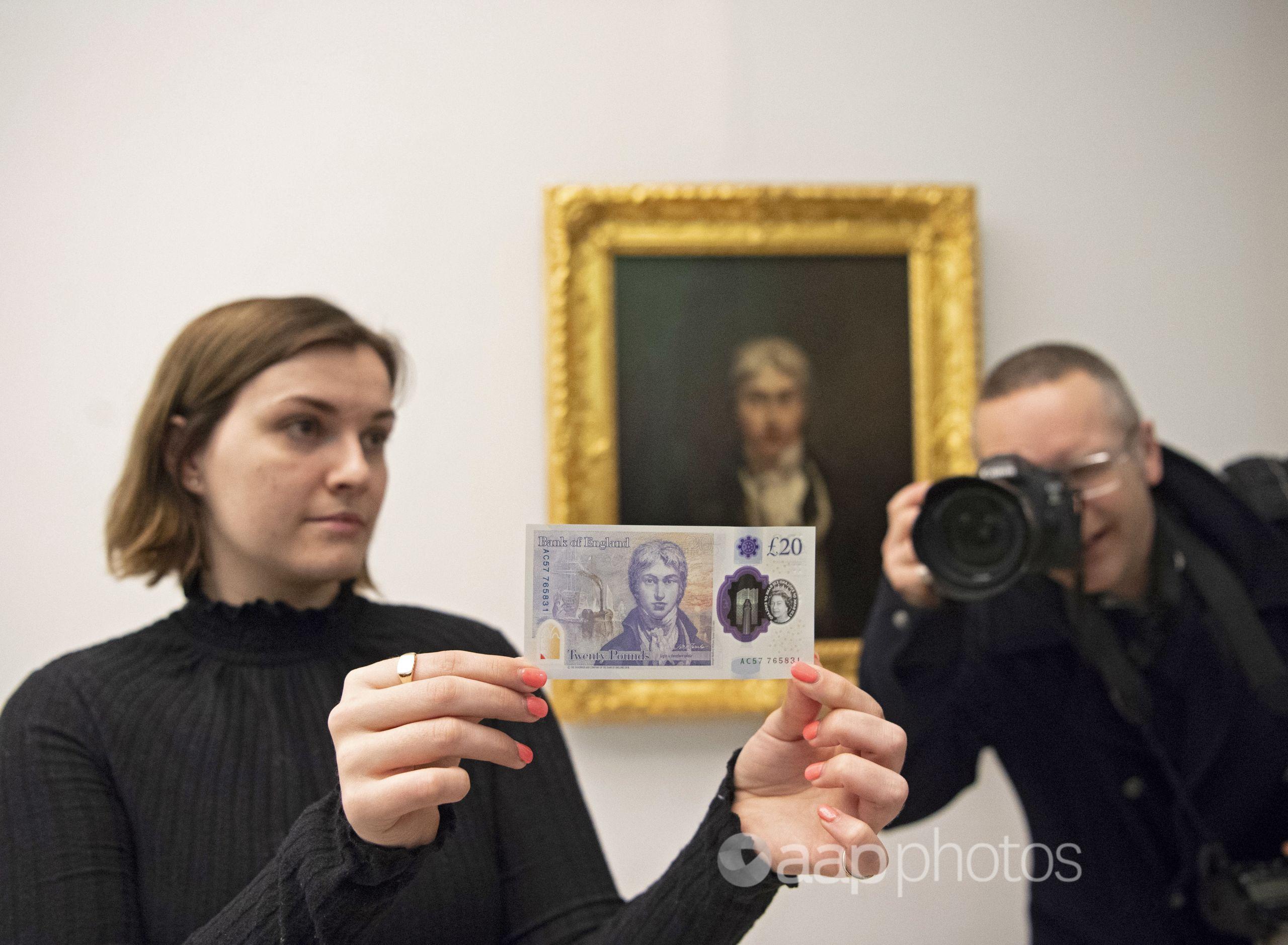 A Tate Britain employee poses with the 20 pound note.