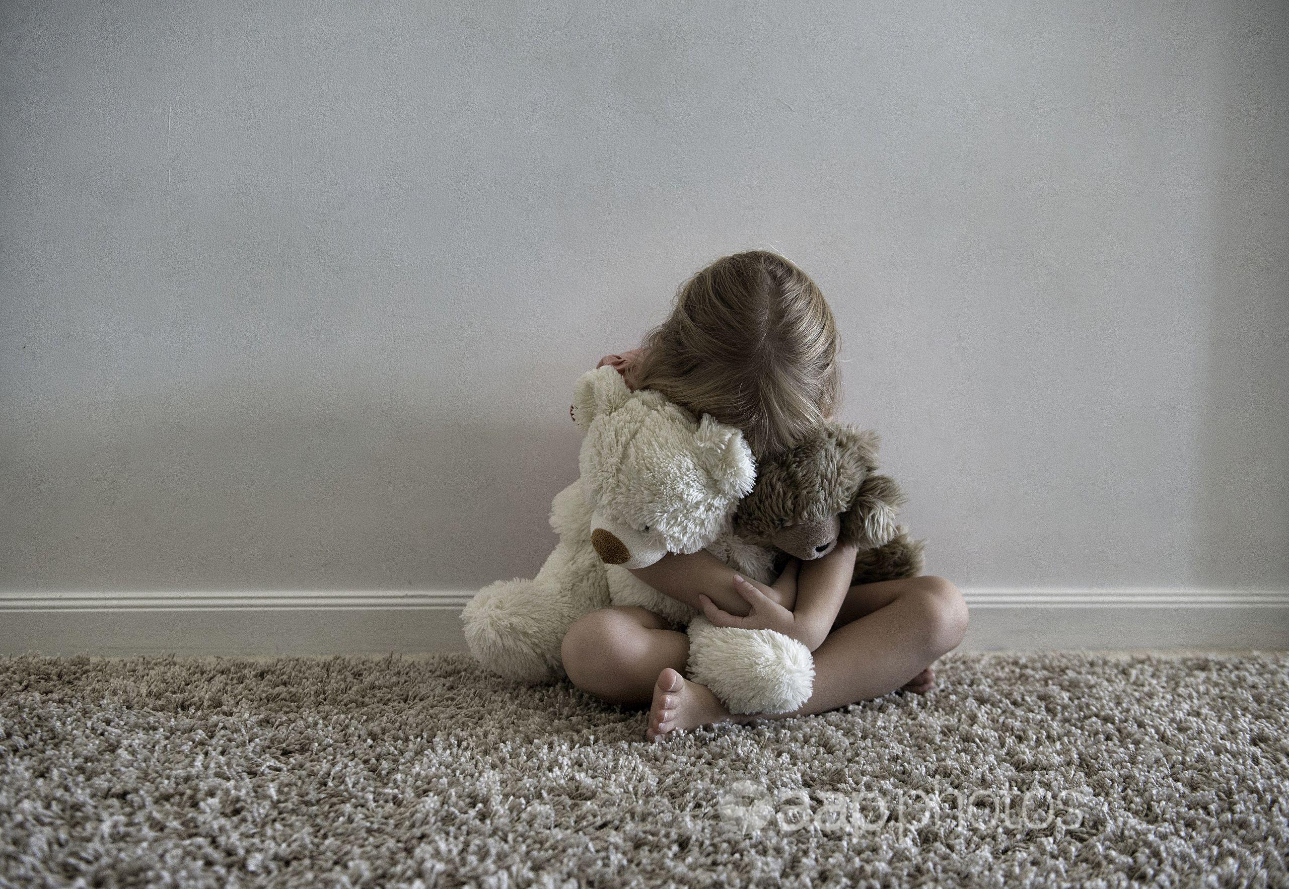 A little girl hugging toys.