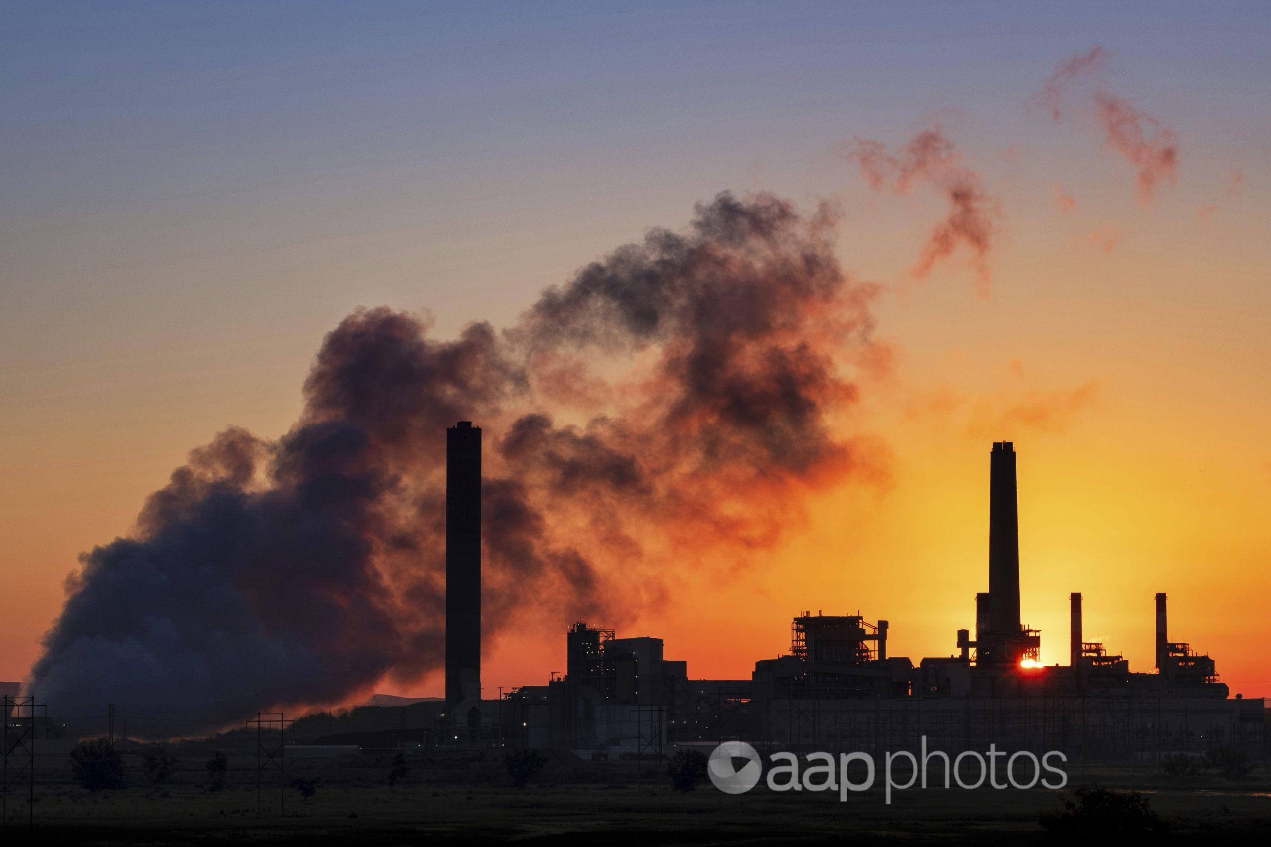 Coal-fired power station silhouetted at sunset