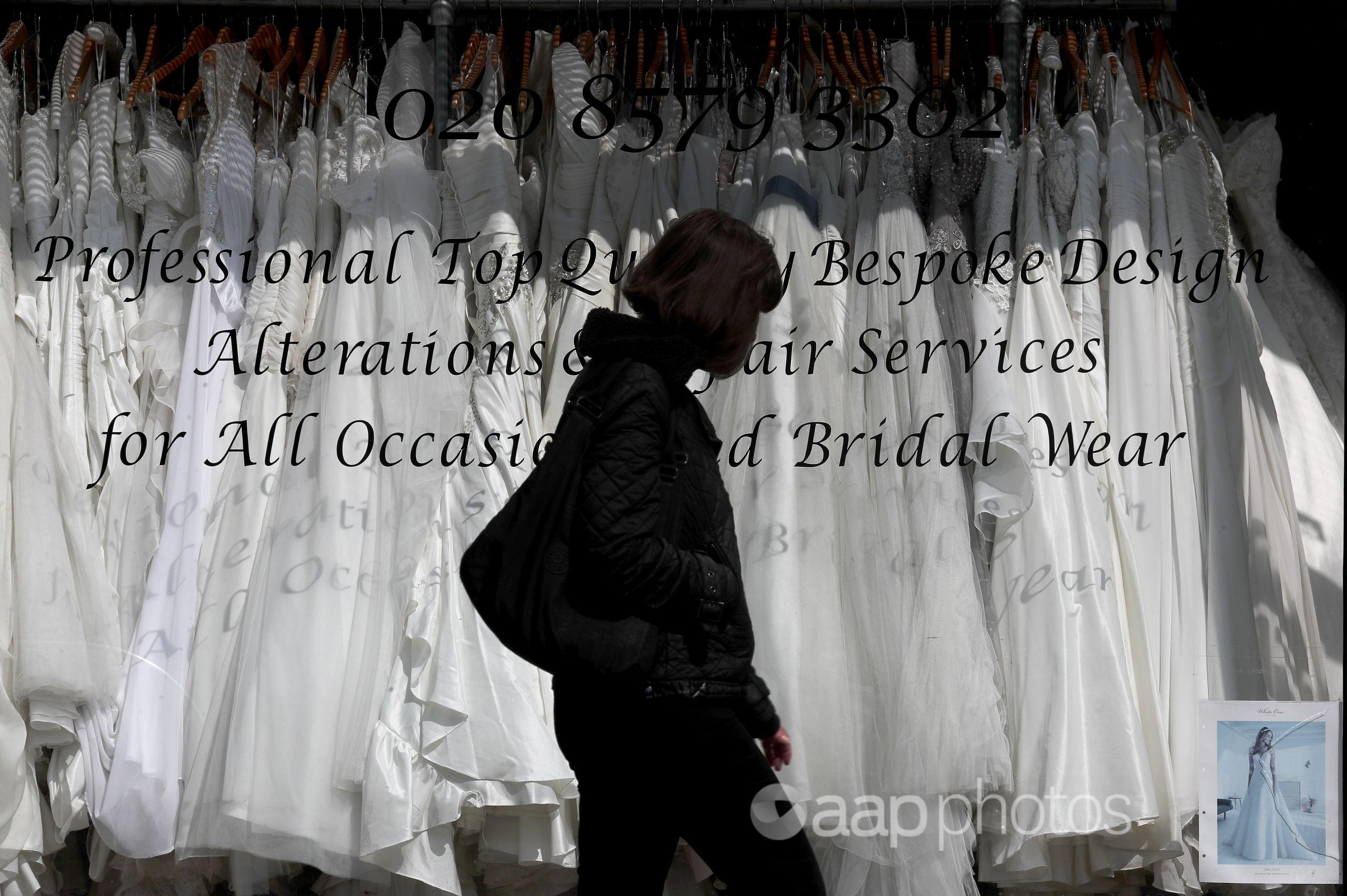 A woman walks past a wedding dress shop in London.