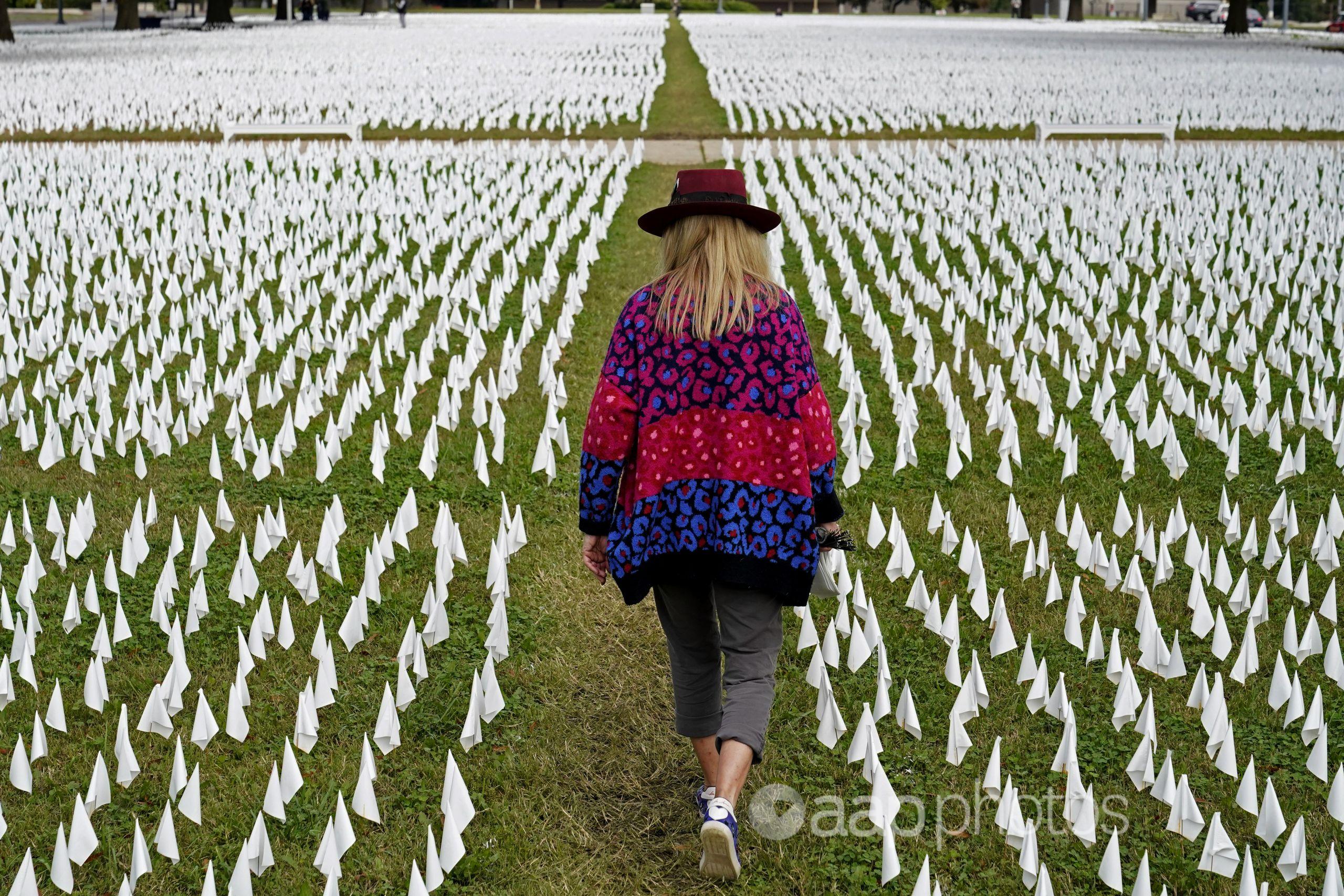 A woman walks among white flags  in Washington.