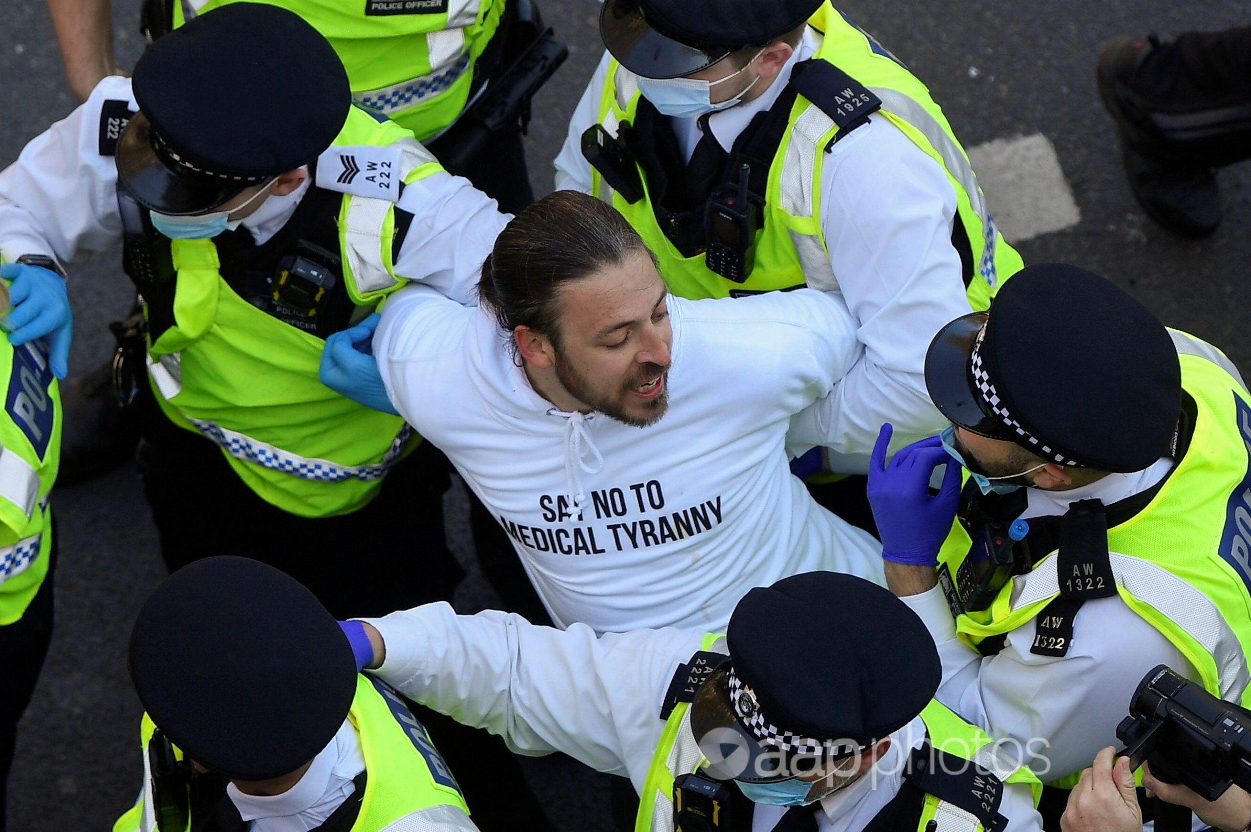 Police detain a demonstrator during the anti-lockdown protest