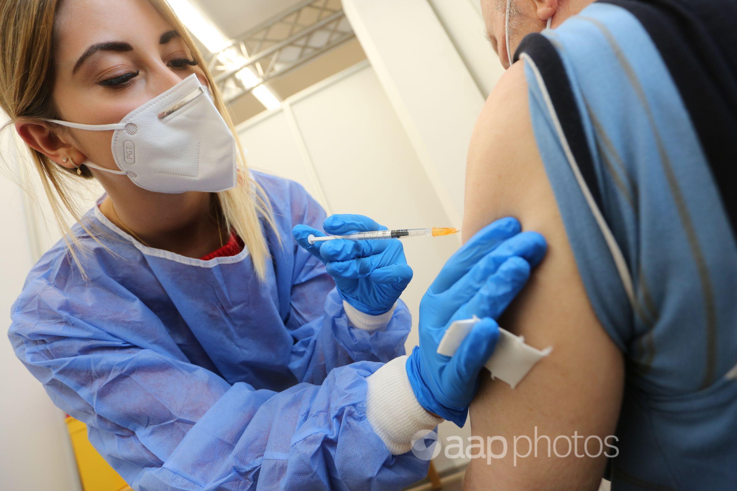 A nurse administers a COVID-19 vaccination shot.