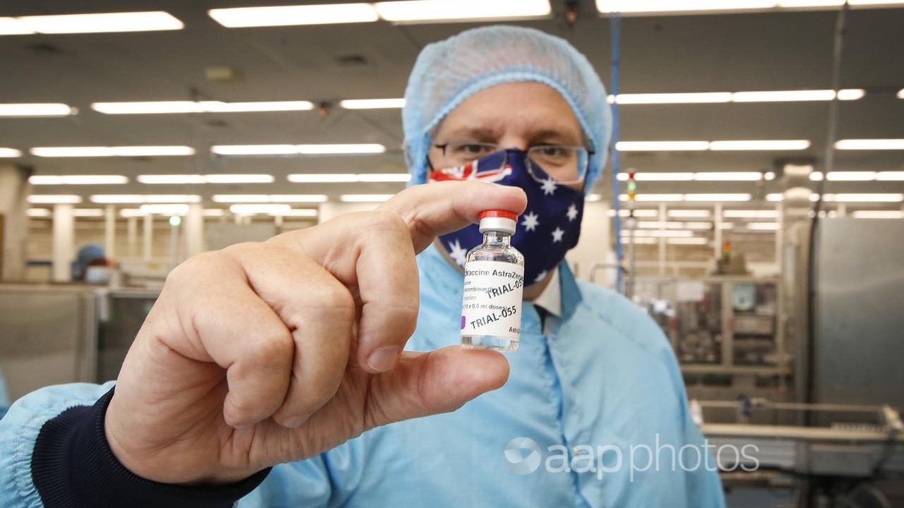 Prime Minister Scott Morrison holds a COVID-19 vaccine dose.