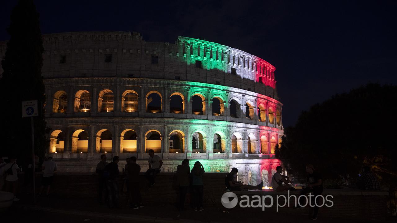 The Colosseum in Rome illuminated in the colours of the Italian flag