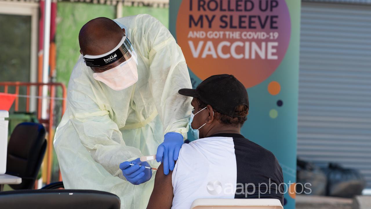 An indigenous man is vaccinated at a COVID-19 clinic