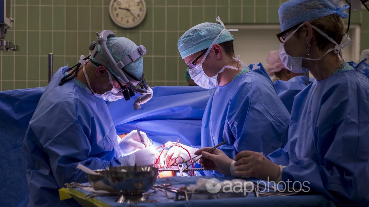 Cardiac surgeons operate a young sportsman at a hospital.