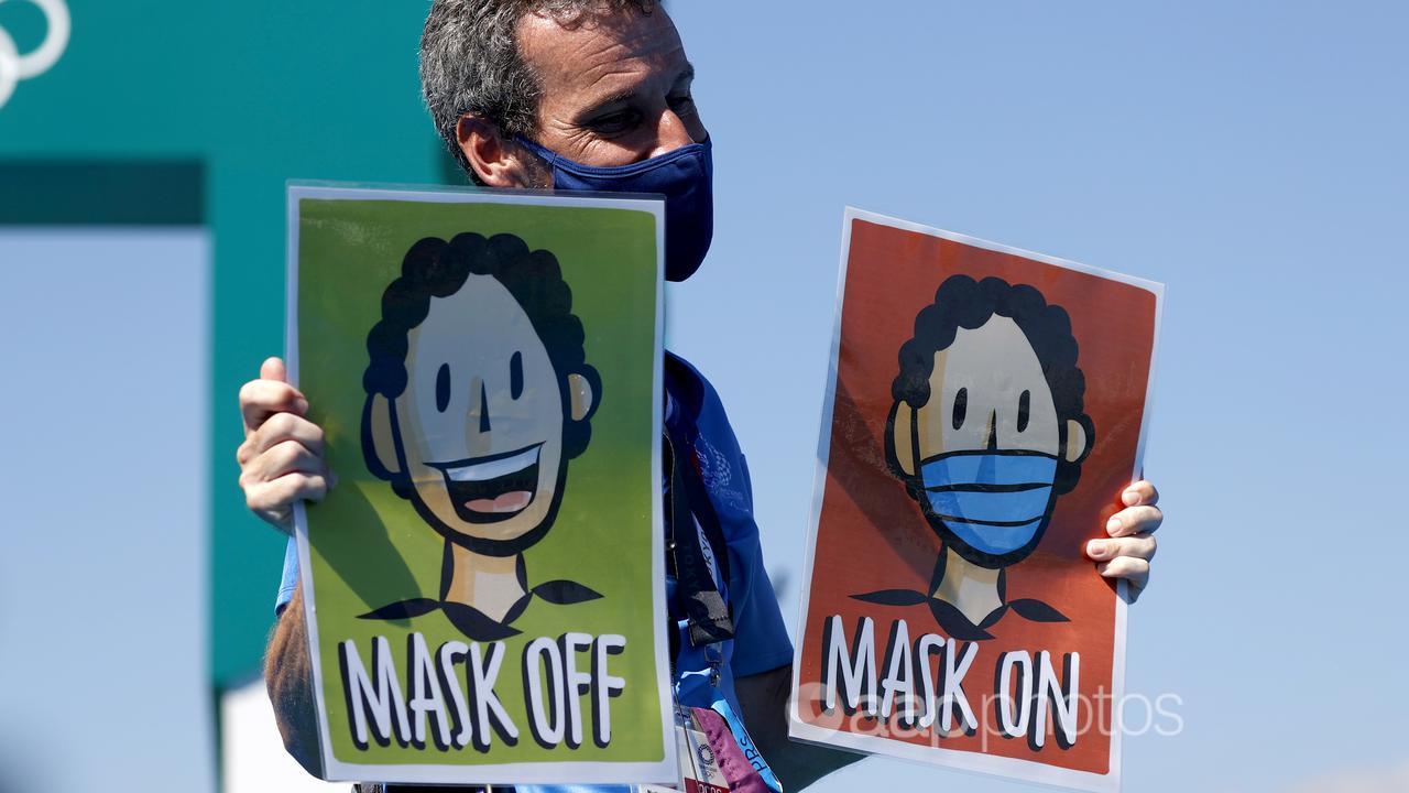 A volunteer holds mask signs the Tokyo 2020 Olympics (file image)