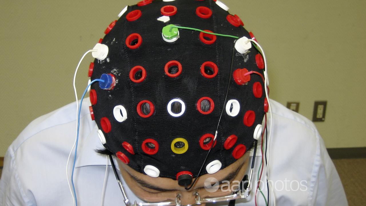 A researcher shows a cap that can read brain signals.