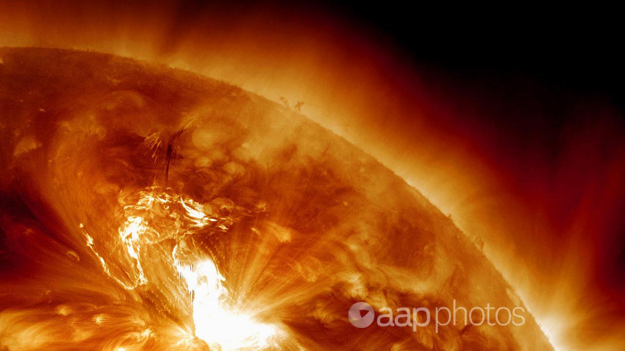 aA solar flare erupting on the Sun's northeastern hemisphere