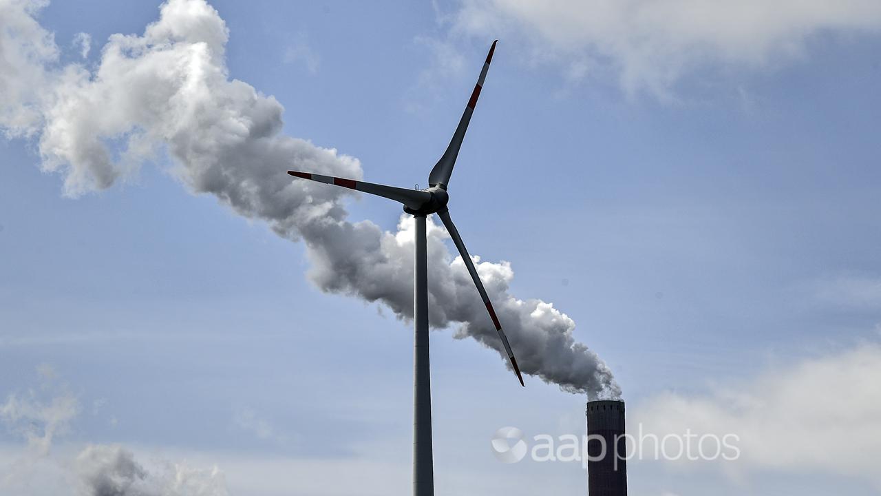 A chimney of a coal-fired power plant beside a wind turbine in Germany