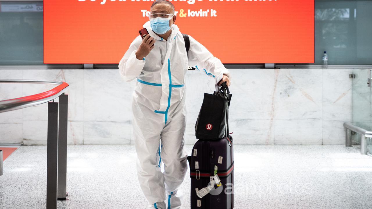 Pictured, a traveller in PPE at Sydney Airport.