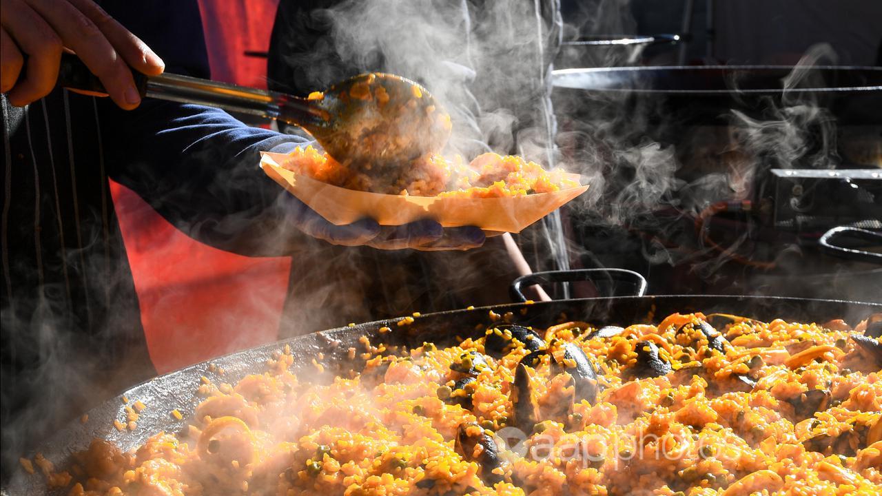 A server dishes a plate of paella