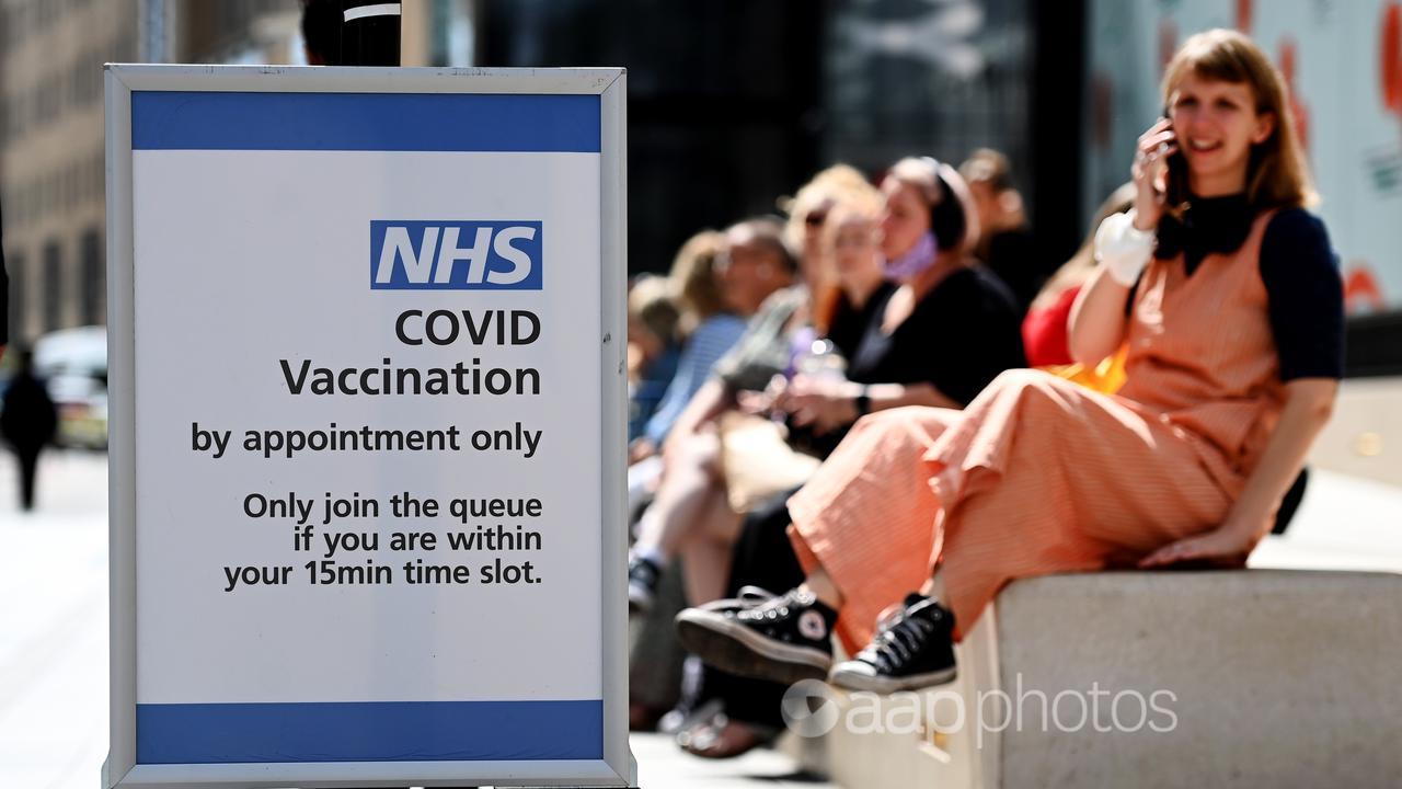 People line up at a COVID vaccination centre in London.