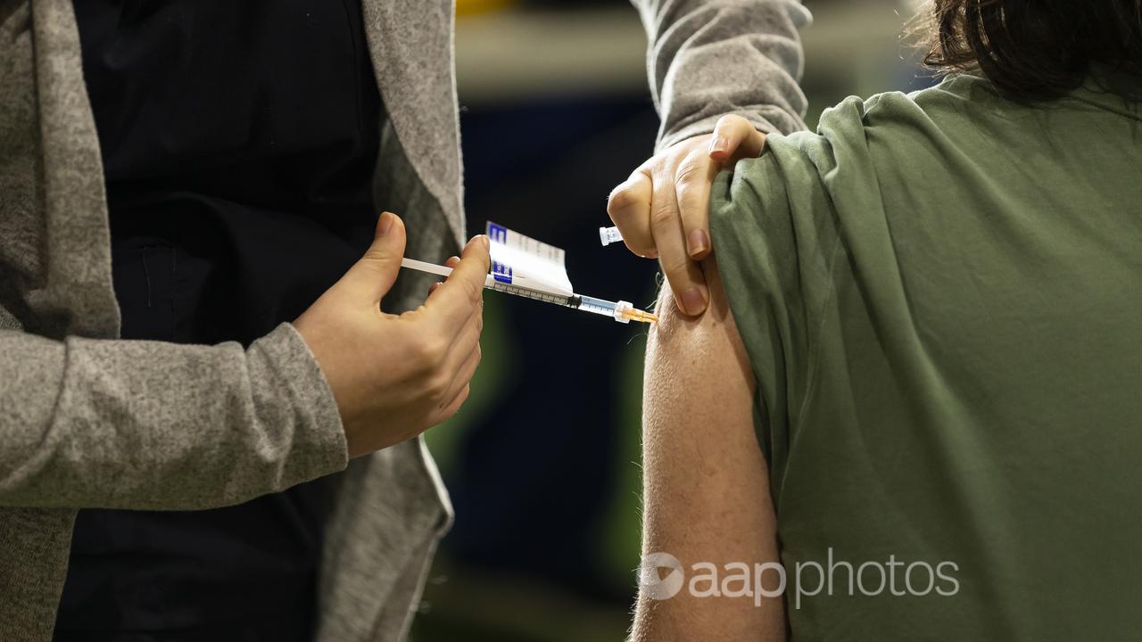 A person receives a vaccination at a COVID-19 clinic in Melbourne.