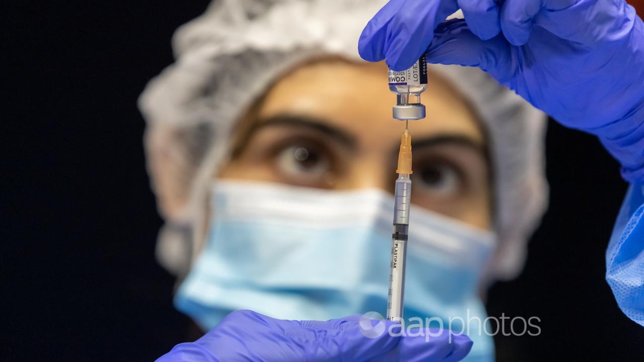 A health care worker fills a syringe with Pfizer vaccine (file image)