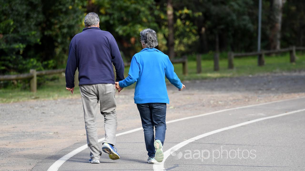 An elderly couple walk through a park (file)