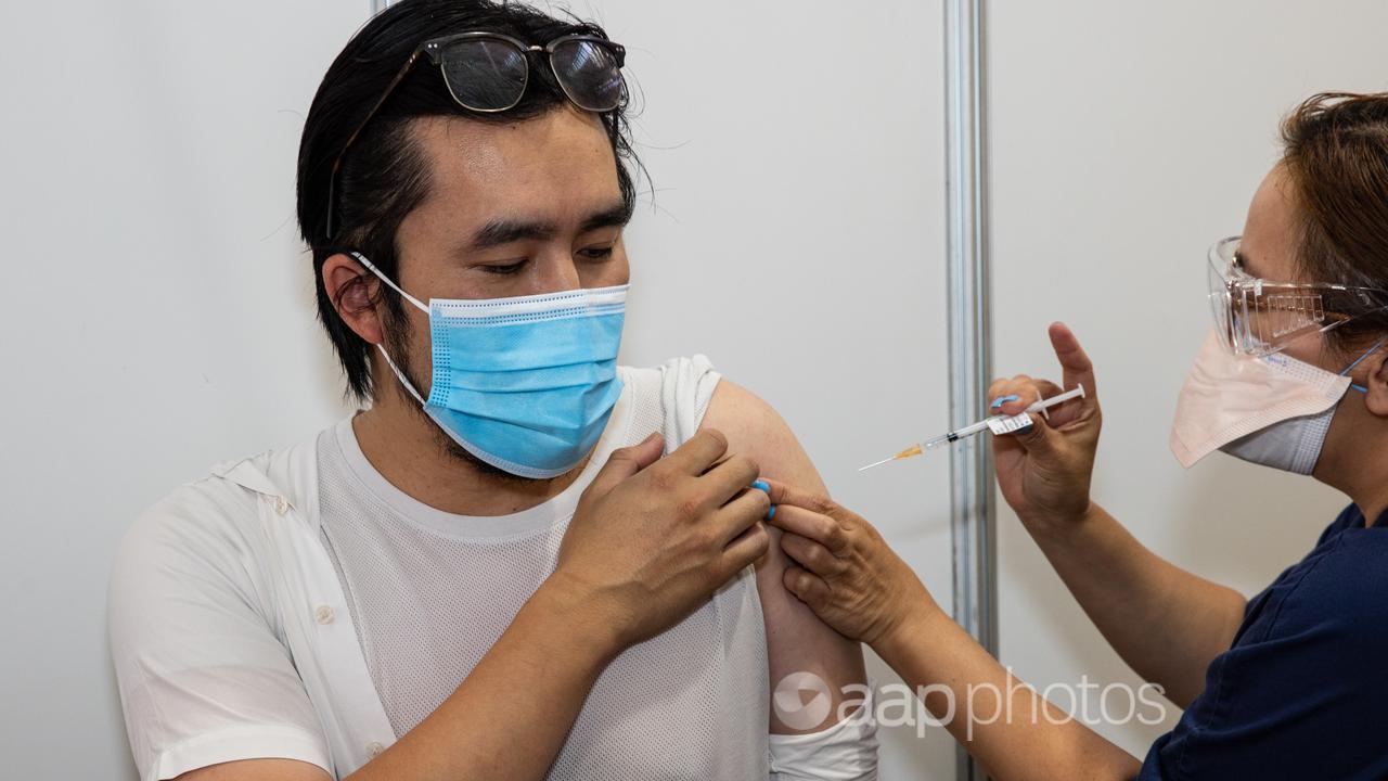 A health worker administers the COVID-19 vaccine