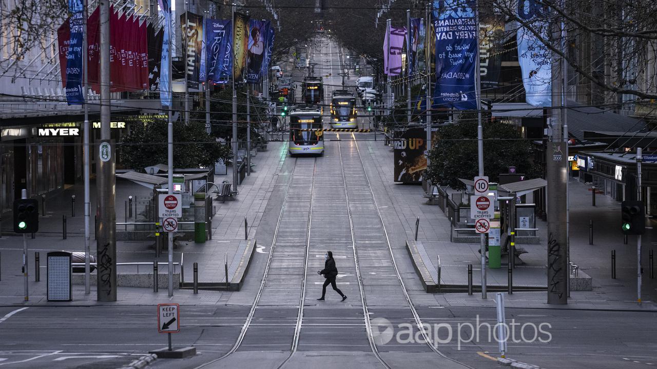 A person crosses a quiet Bourke Street in Melbourne