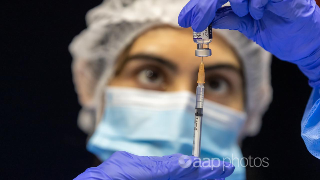 A health care worker fills a syringe with Pfizer vaccine (file image)