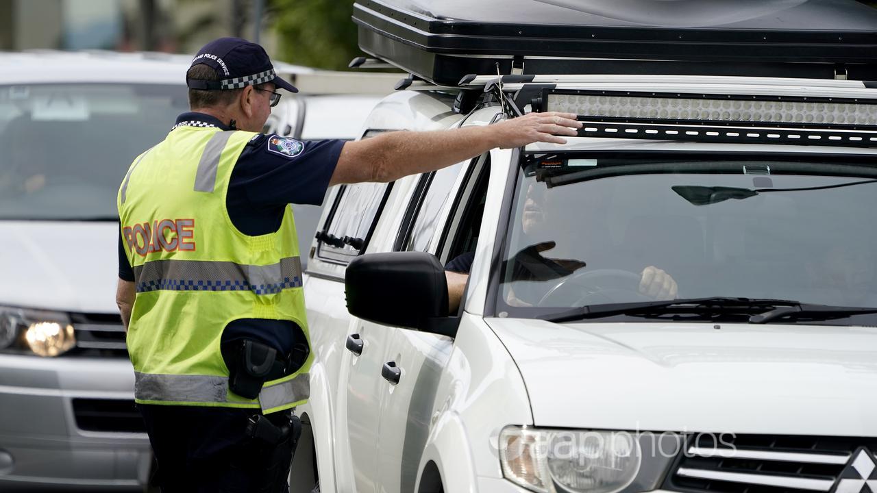 A Queensland police officer gestures for a motorist.