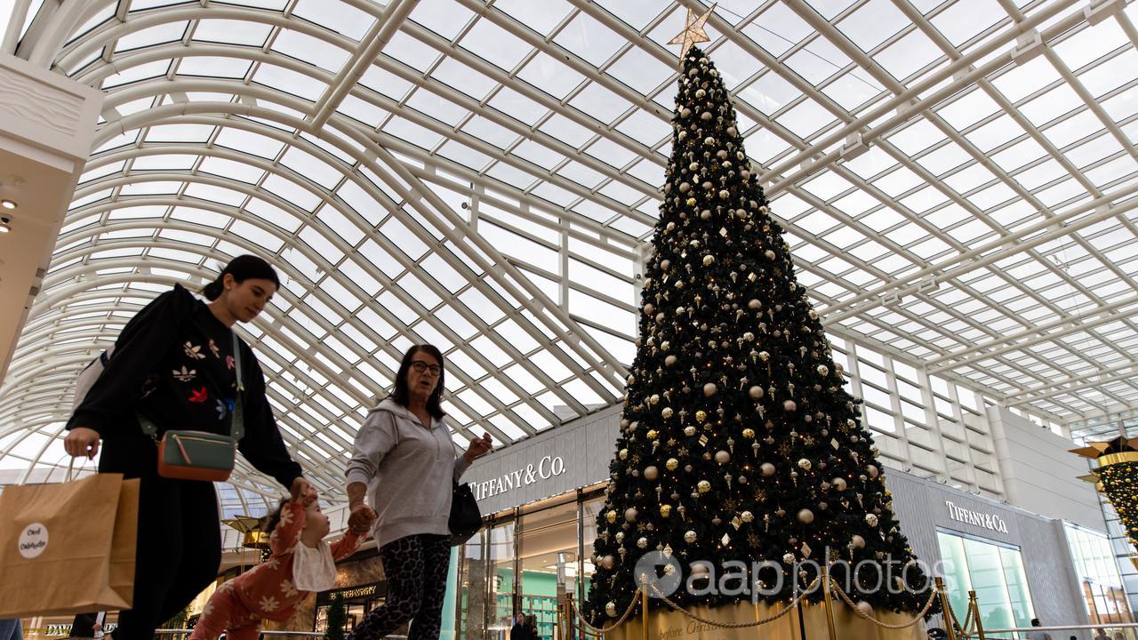Shoppers walk past a Christmas tree in Melbourne.