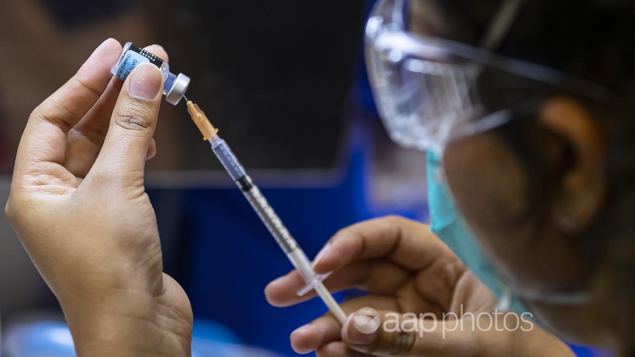 A health care worker prepares a Pfizer vaccine (file image)