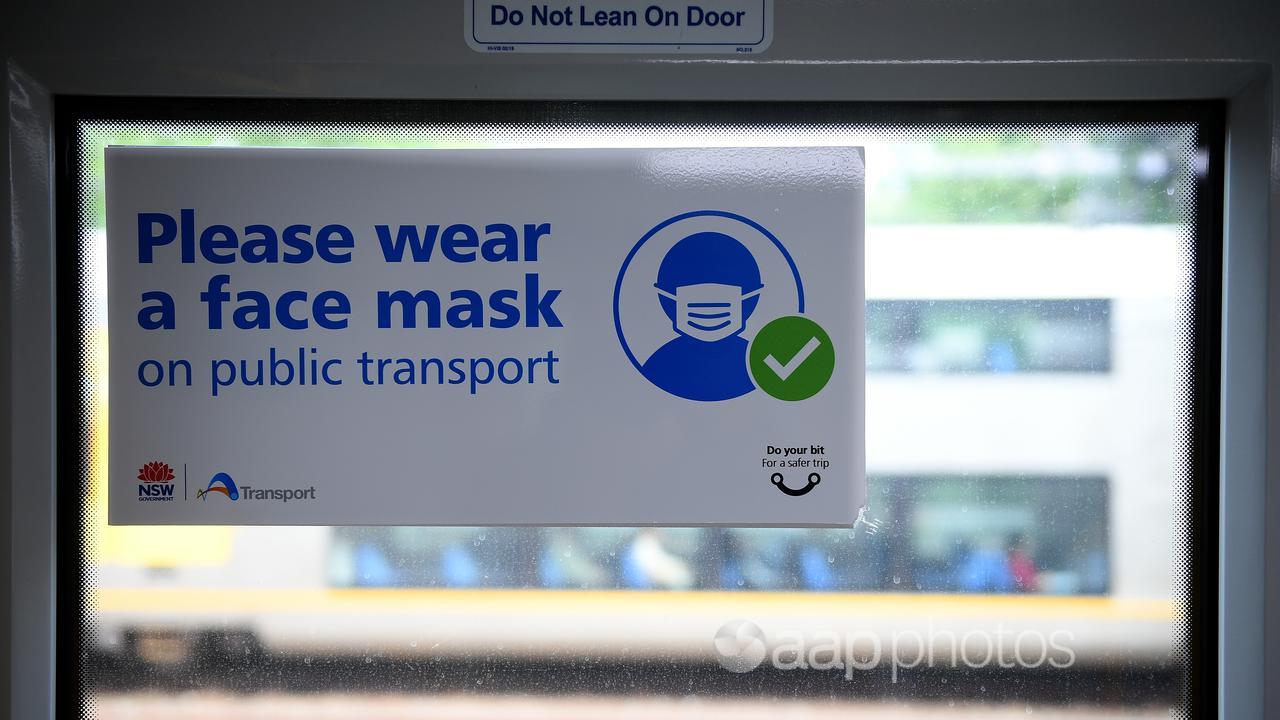 A sign urging commuters to wear a face mask (file image)