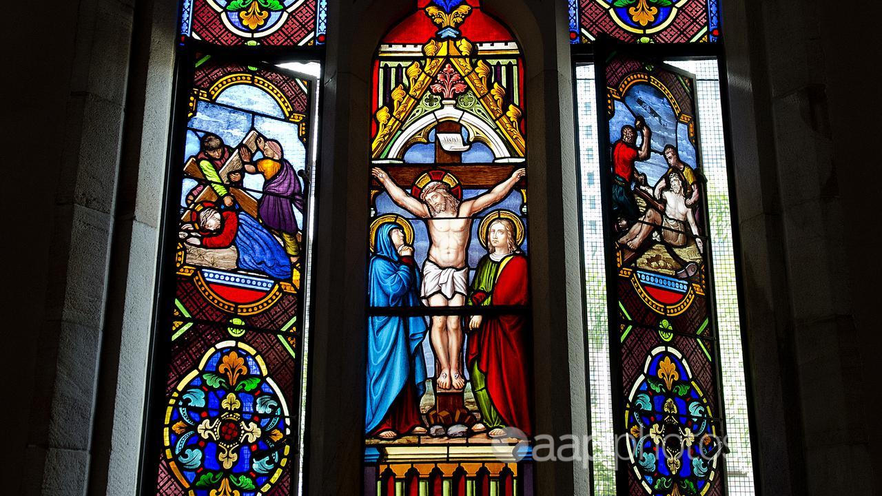 A stained glass window depicting Jesus Christ crucified on the cross.
