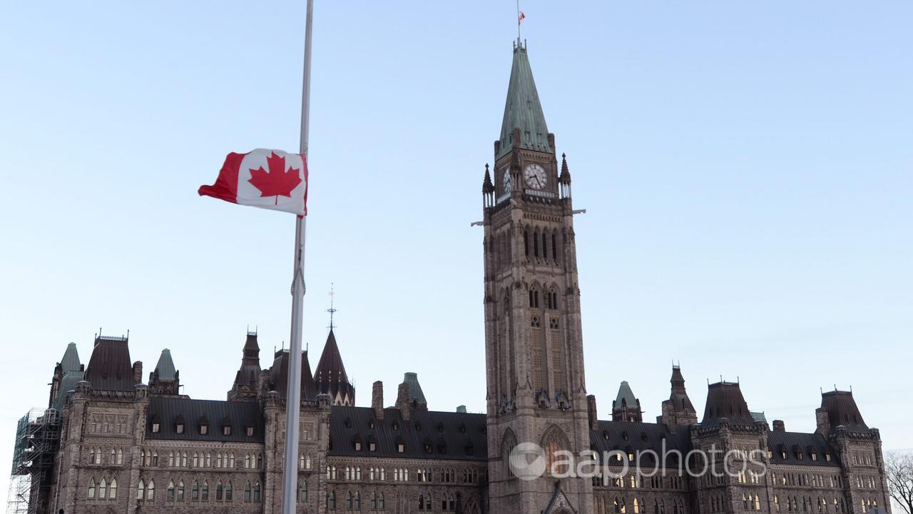 The Canadian flag flies at half mast at Parliament Hill in Ottawa