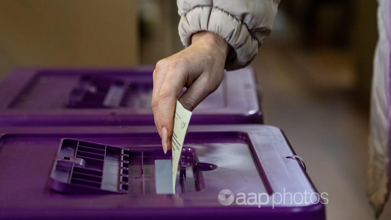 A person places a vote in a ballot box (file image)