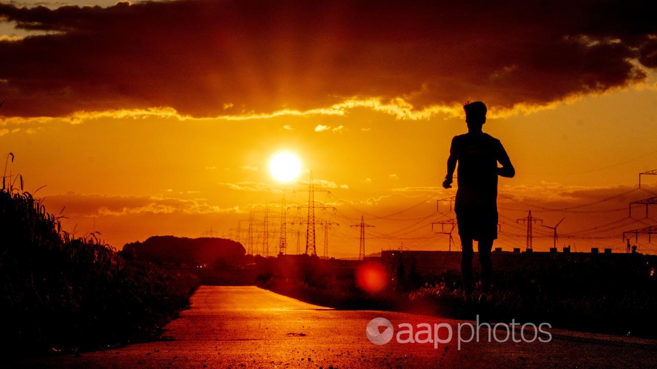 A man runs along a small road at sunrise (file image)