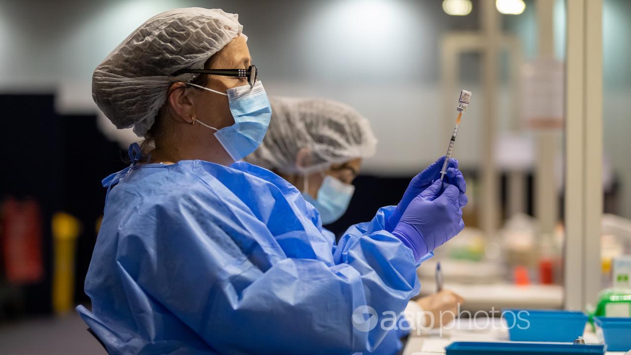A health care worker fills a syringe (file image)