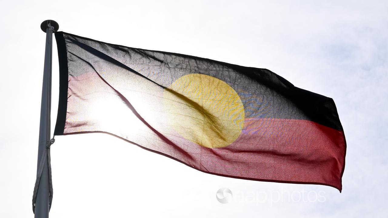 An Aboriginal flag flies in front of the sun