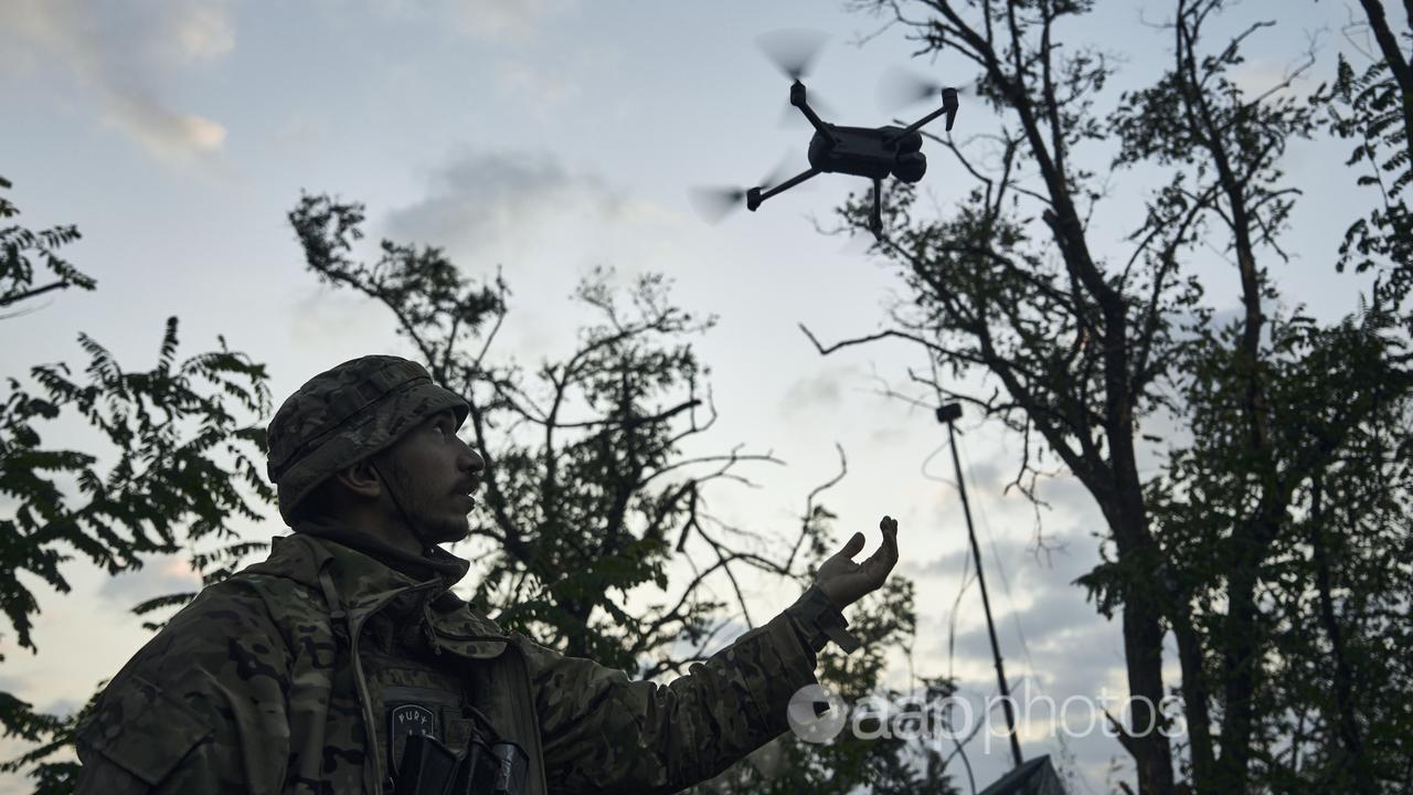 A Ukrainian soldier launches a drone