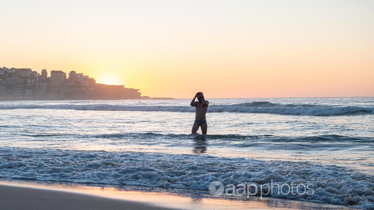 A man leaves the surf on a warm Monday at Bondi.