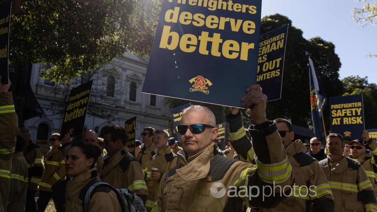 Firefighters hold placards during a protest in Melbourne.