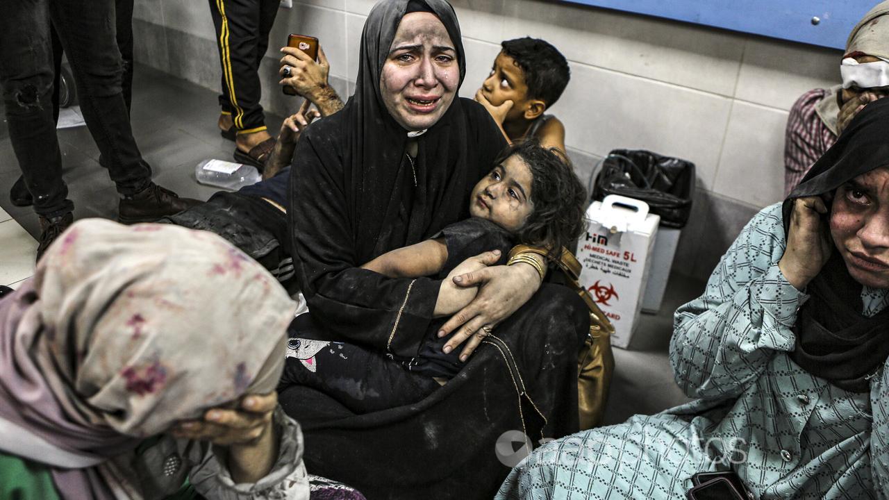 Wounded Palestinians sit in al-Shifa hospital in Gaza