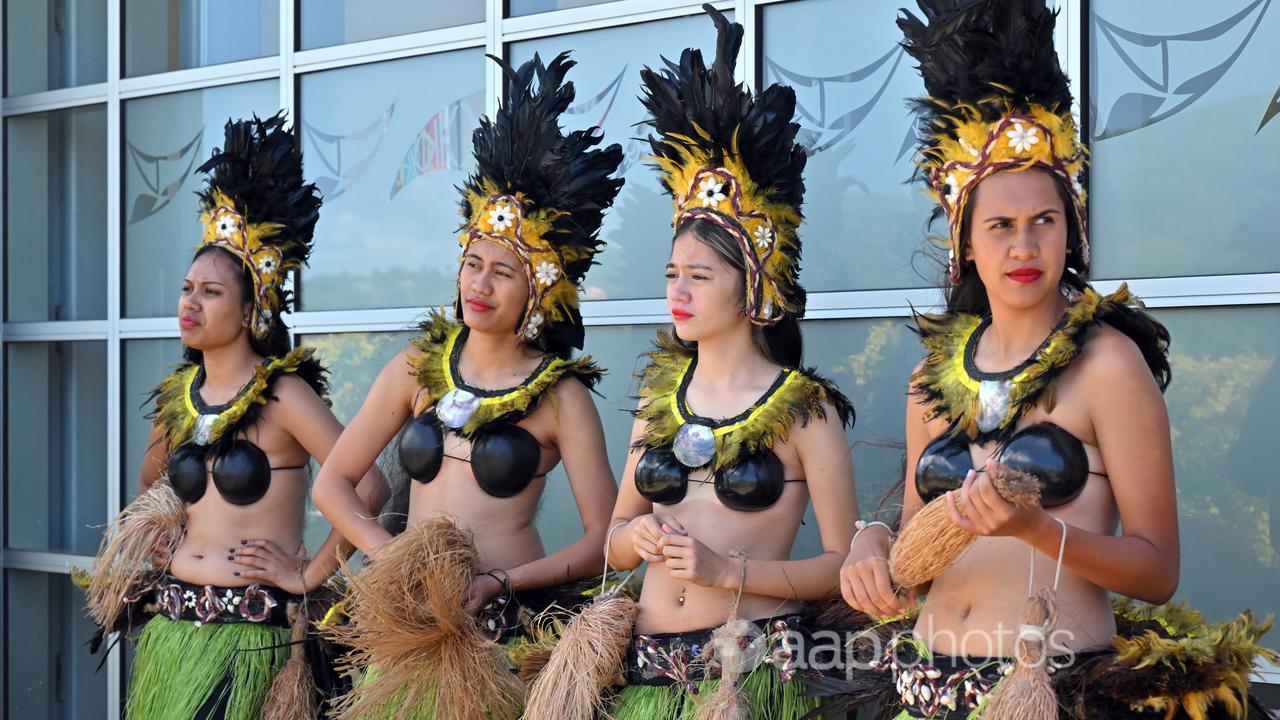 Women in traditional costume wait for Anthony Albanese in Rarotonga