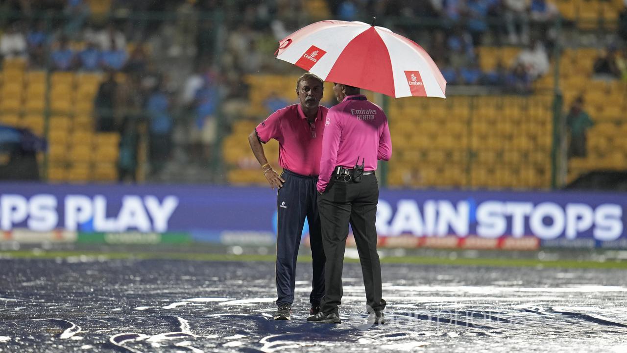 Umpires standing in the rain.