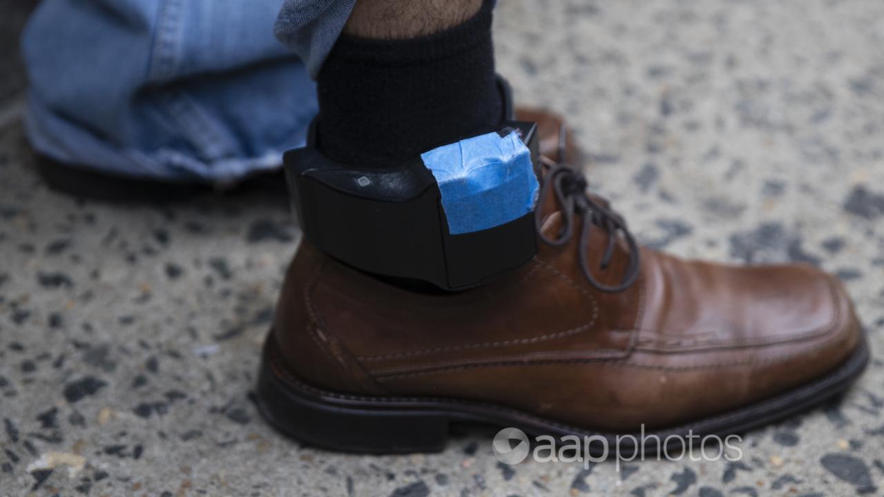 A man wearing an ankle tracking device.