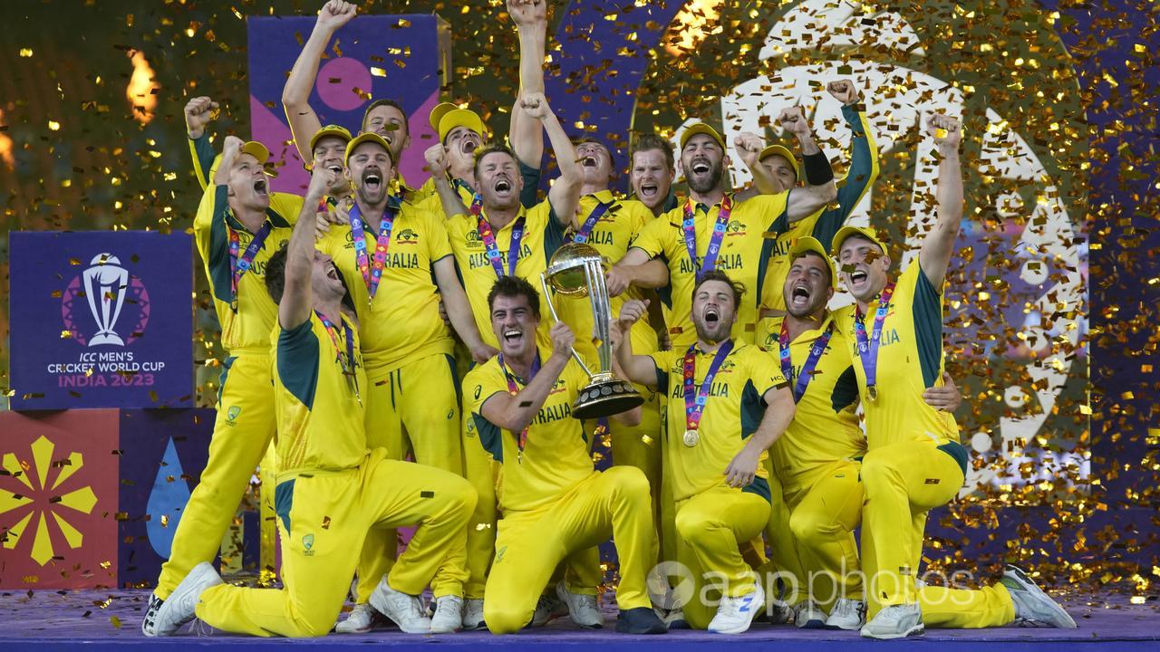 Australian players celebrate with the World Cup trophy.