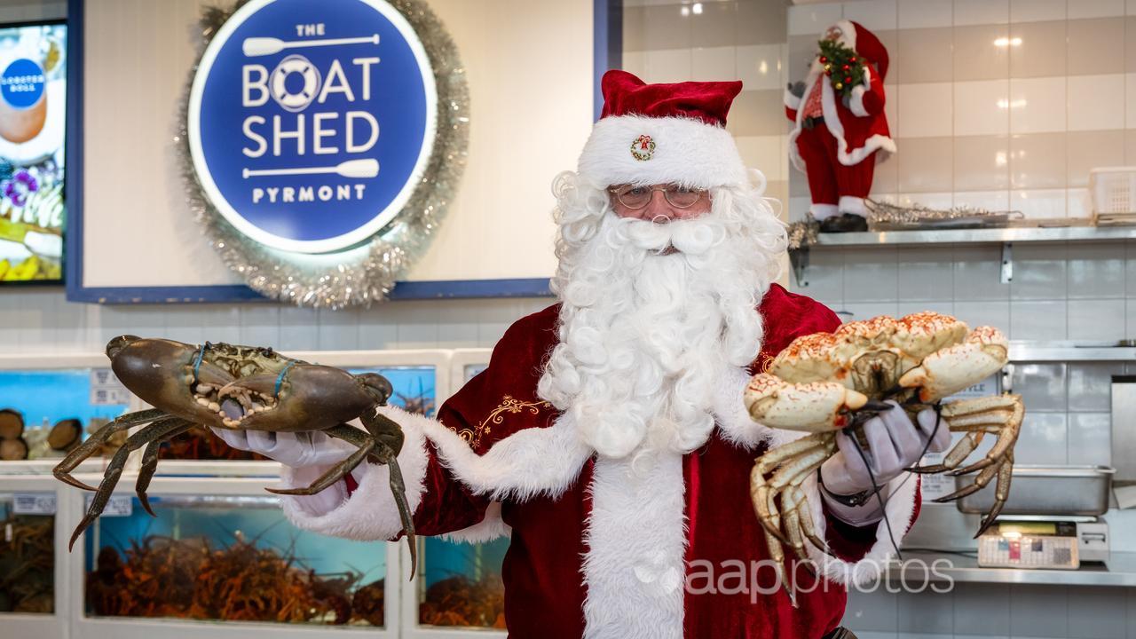 Santa Claus shows off some crabs.