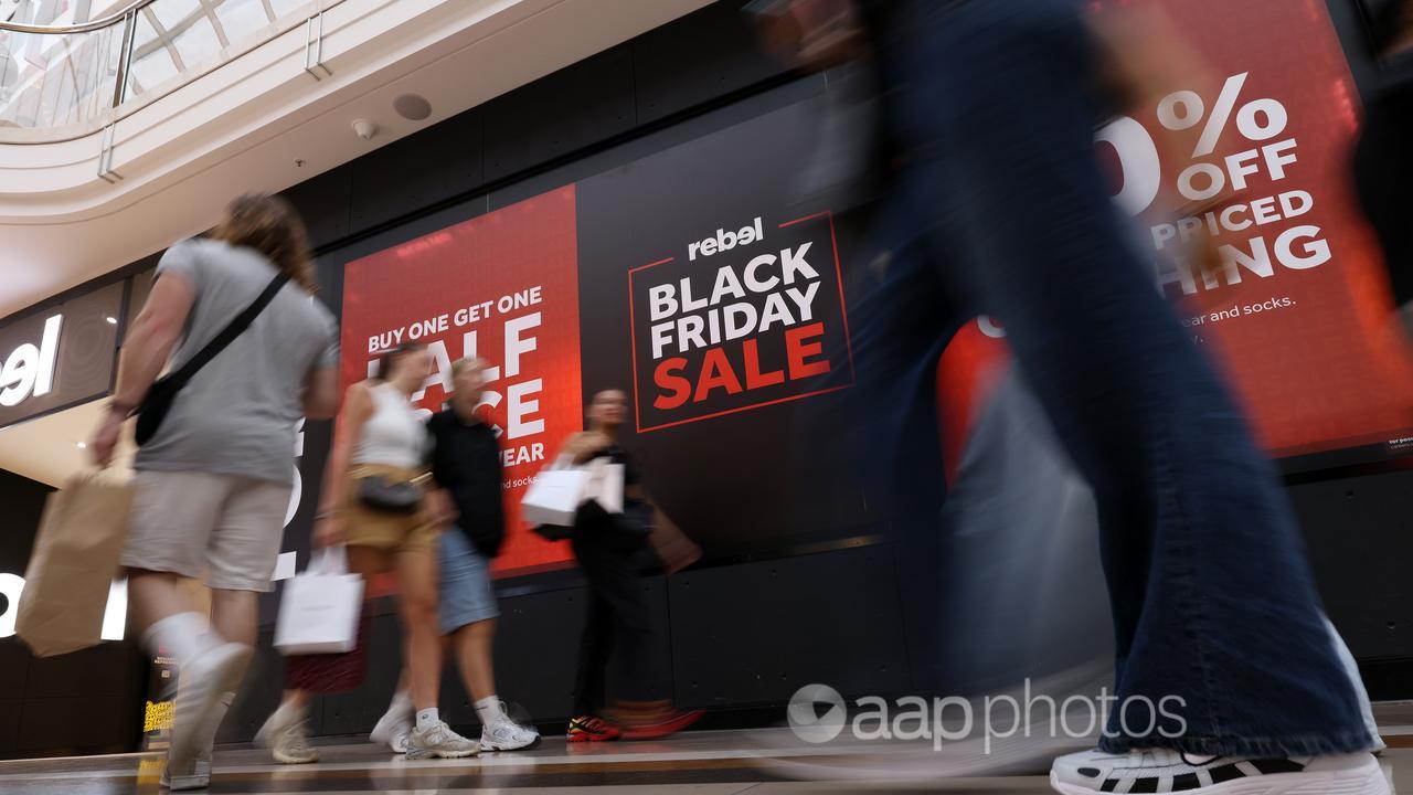 Shoppers walk by Black Friday Sale signage (file image)