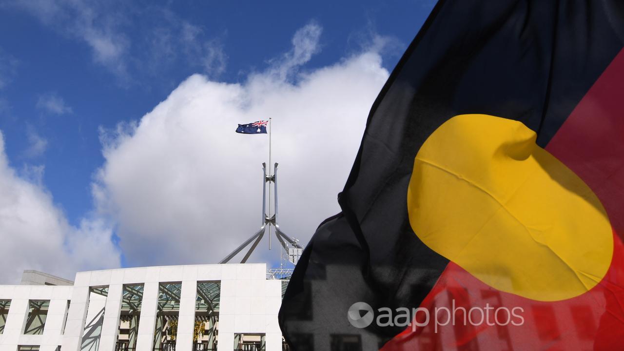 Parliament House viewed through an Aboriginal flag in Canberra