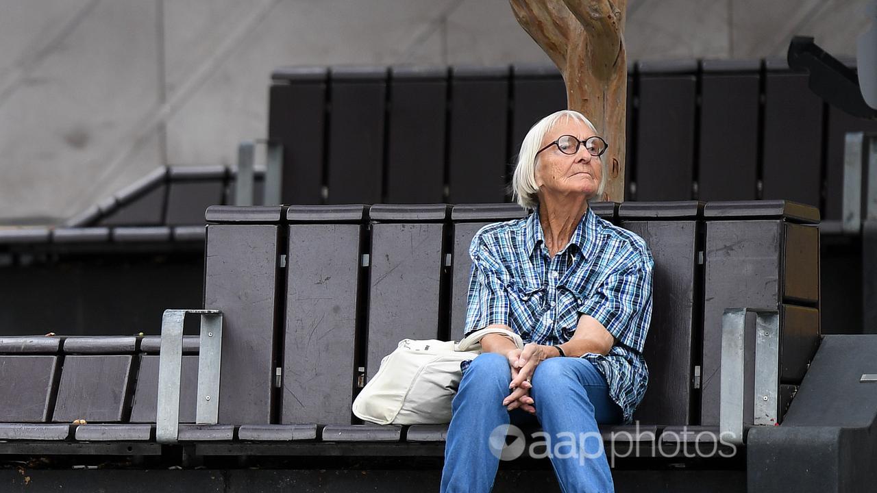 An elderly woman sits on a bench in Brisbane (file)