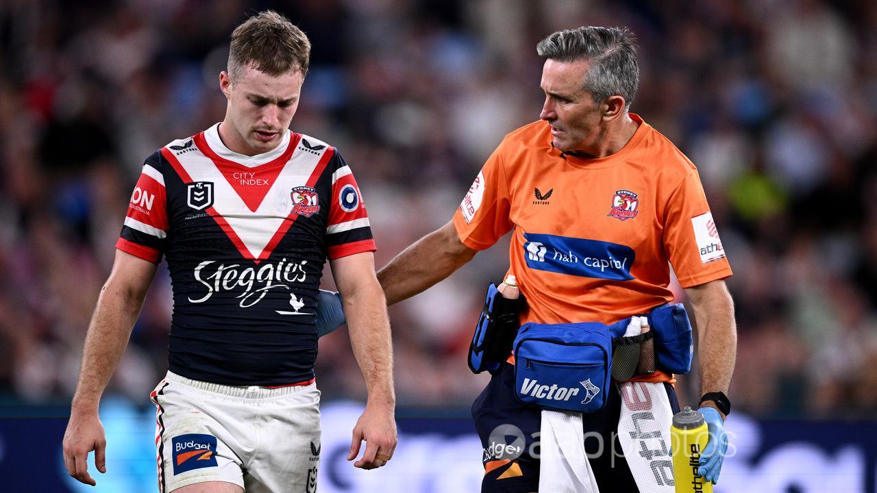 Sydney Roosters' Sam Walker (left) goes off field for an HIA. 