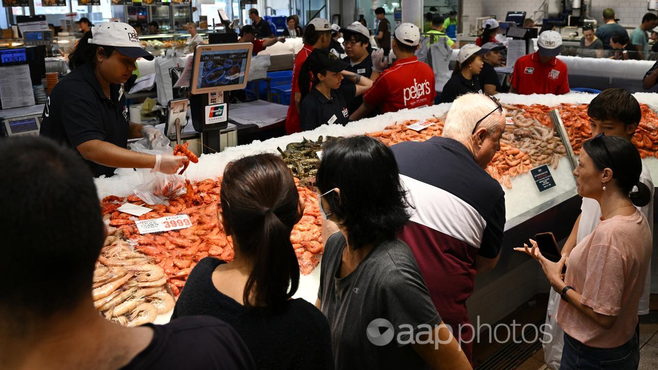 Crowd of people buying seafood.