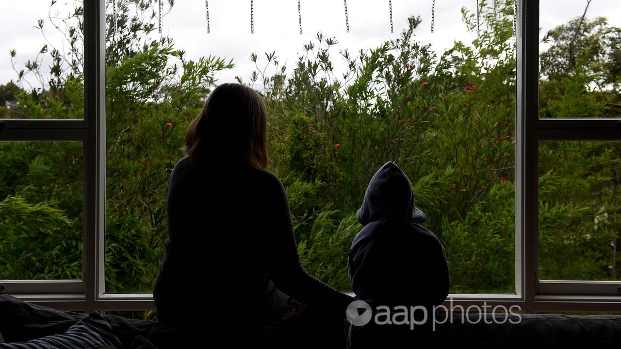 A woman and a child silhouetted against a window.